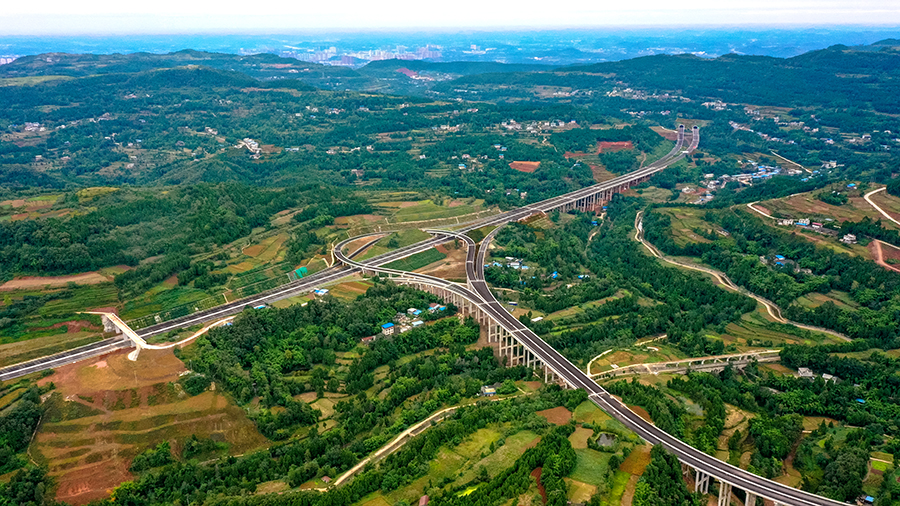德簡高速公路位于2008年汶川地震最嚴(yán)重區(qū)域，沿線人口稠密，地形復(fù)雜，路網(wǎng)密集。參建人員堅持綠色環(huán)保理念施工，常態(tài)化推進(jìn)生態(tài)防護(hù)，全力打造“青山綠水”工程。圖為隆興互通。