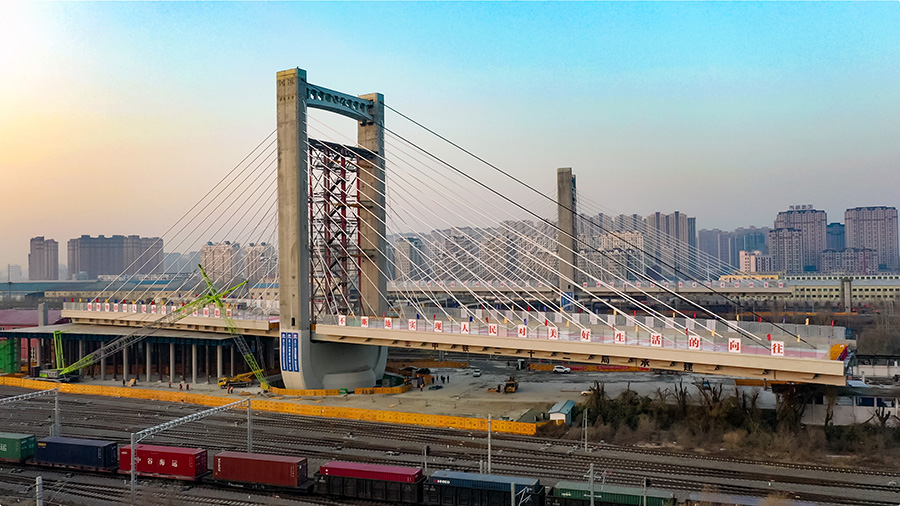 這座橋梁長843米、寬30米，雙向6車道，為混凝土現(xiàn)澆連續(xù)梁結(jié)構(gòu)，上跨哈爾濱鐵路局管內(nèi)最大路網(wǎng)性編組站哈爾濱南站的48條鐵路既有線和1條市政主干道，主跨長198米，兩側(cè)邊跨各長118米，兩座主塔高73.7米。圖為緩緩轉(zhuǎn)動的哈西大橋主塔和連續(xù)梁。