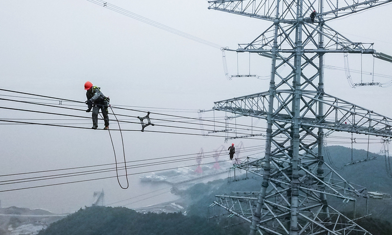 圖為10月23日，檢修人員在跨海輸電高塔上進行走線工作。（新華社記者 徐昱 攝）