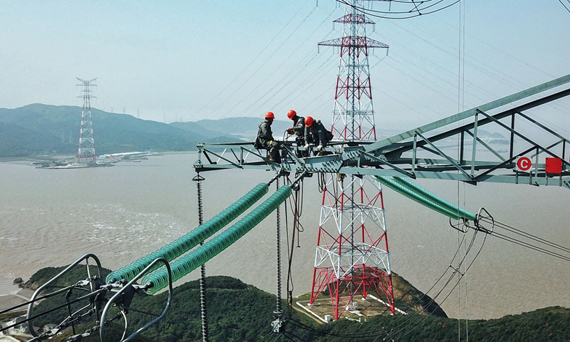 圖為10月24日，檢修人員在跨海輸電高塔上進行檢修工作。（新華社記者 徐昱 攝）