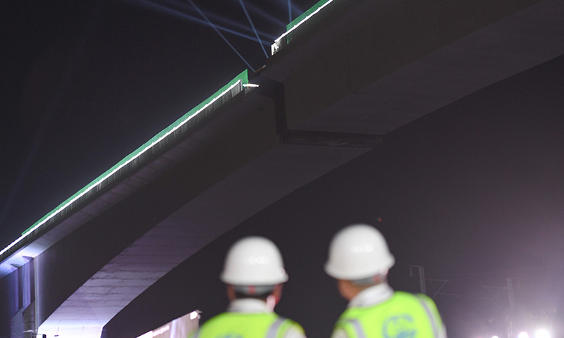 9月24日凌晨，中鐵四局承建的新建福廈鐵路西溪特大橋跨杭深鐵路連續(xù)剛構(gòu)轉(zhuǎn)體梁成功轉(zhuǎn)體。轉(zhuǎn)體梁采用雙幅同步轉(zhuǎn)體，單個轉(zhuǎn)體長168米，重約19000噸。圖為9月24日，技術(shù)人員在參與新建福廈鐵路西溪特大橋跨杭深鐵路連續(xù)剛構(gòu)轉(zhuǎn)體梁轉(zhuǎn)體施工。（新華社記者 宋為偉 攝）