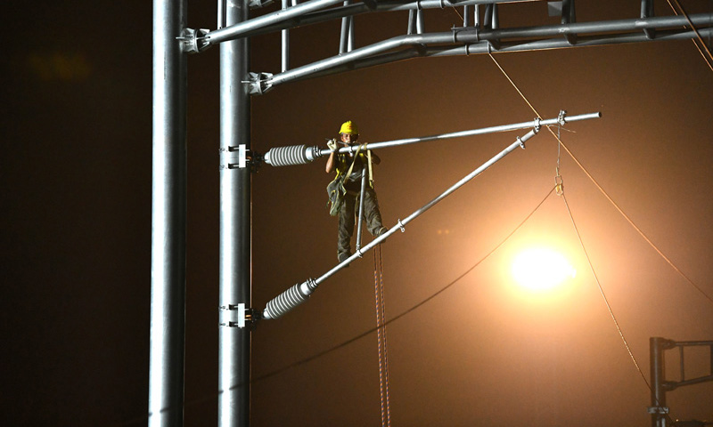 圖為9月1日凌晨，中鐵建電氣化局南方公司施工人員在合安高鐵集賢路線路所接觸網撥接現場施工。（新華社記者 劉軍喜 攝）