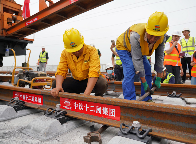 圖為8月17日，中鐵十二局工人在進行鋪軌作業。（新華社記者 牟宇 攝）