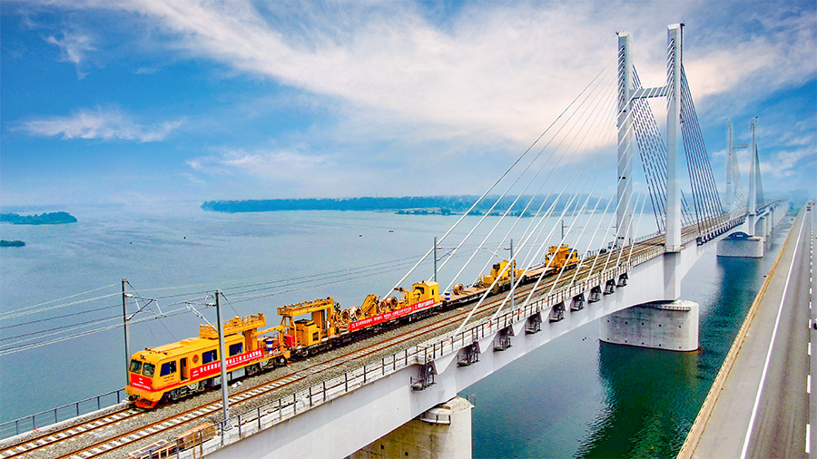 9月28日早上6時30分，首趟105節(jié)貨運列車滿載8400噸煤炭從浩勒報吉南站駛出，標志著世界上一次性建成并開通運營里程最長的重載鐵路——浩勒報吉至吉安鐵路（以下簡稱浩吉鐵路，即原蒙西至華中地區(qū)鐵路）開通運營。浩吉鐵路全長1813.5公里，北起內(nèi)蒙古鄂爾多斯市浩勒報吉南站，終到京九鐵路吉安站。它的開通，改變了中國鐵路煤炭運輸格局，為我國鐵路版圖新增一條縱貫南北的能源運輸大通道。圖為中國鐵建電氣化局浩鐵路漢江特大橋上接觸網(wǎng)軌道車施工。
