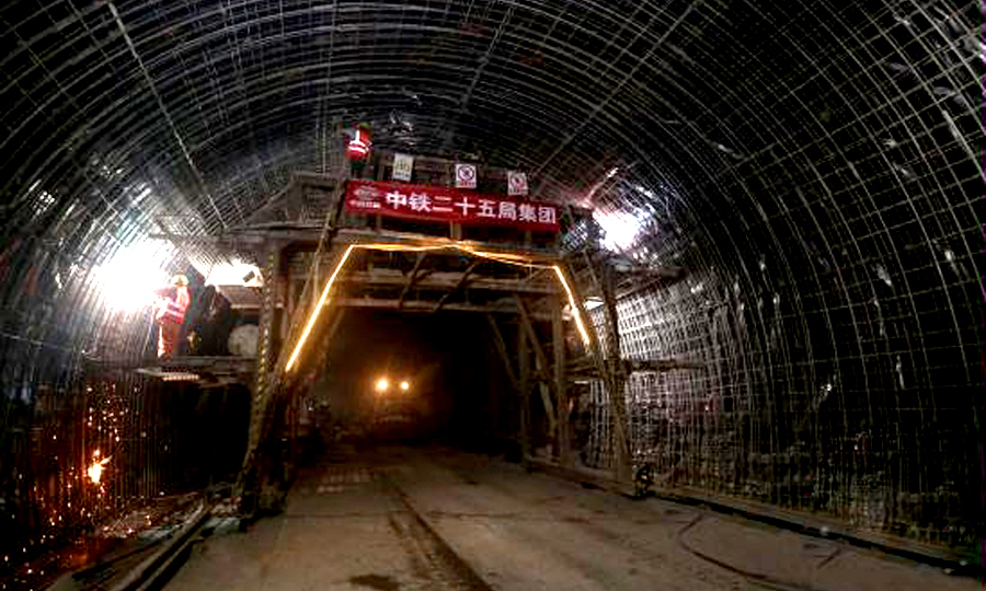 針對鐵峰山隧道復(fù)雜地質(zhì)，中鐵二十五局采取有毒有害氣體檢測、沉降觀測等措施，運(yùn)用地質(zhì)雷達(dá)、超前預(yù)報、激發(fā)極化法等探測方法，對復(fù)雜地質(zhì)進(jìn)行“望聞問切”，有效規(guī)避安全風(fēng)險。圖為施工人員綁扎加固二襯鋼筋。（蔡如錦 攝）