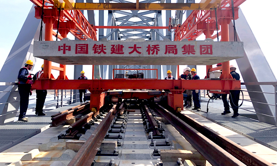 同江中俄鐵路大橋是中國首座跨境四線套軌板式無砟軌道鐵路大橋，可適應(yīng)中俄兩國不同規(guī)格的軌距。大橋無砟軌道板為四線套軌板式結(jié)構(gòu)，俄方軌距線路在左為1520mm，國內(nèi)軌距線路在右為1435mm，兩者相差85mm。該板型為國內(nèi)外首次采用。圖為中國鐵建大橋局四公司同江中俄鐵路大橋項目中俄交界最后144米鋪軌。