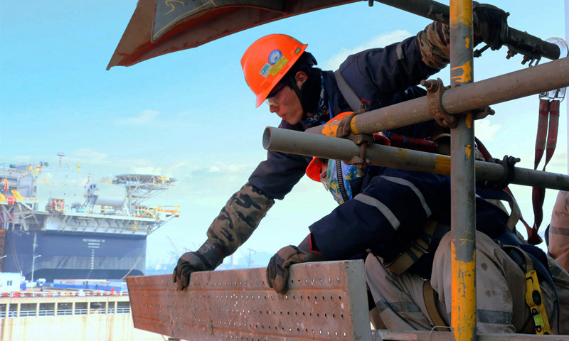殼牌企鵝FPSO（浮式生產(chǎn)儲卸油裝置）是中國海所屬油海油工程公司承攬的第一個殼牌FPSO項目，目前已進入空間建造作業(yè)趕工階段。圖為3月10日，該項目船體建造現(xiàn)場，中國海油高空作業(yè)人員如同高空“衛(wèi)士”，正在全力搭建安全作業(yè)平臺。