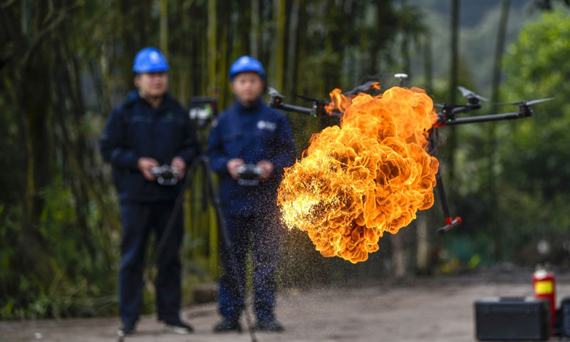 1月16日，經過3年多的研發和測試，重慶首臺噴火清障無人機在國網重慶永川供電公司無人機班正式投用。圖為噴火清障無人機在國網重慶永川供電公司無人機班兩名操作手的控制下進行噴火清障作業演示。（新華社記者 劉潺 攝）
