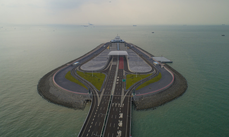 港珠澳大橋香港段由東端的香港口岸人工島和向西連接大橋主體的12公里香港接線組成，是這一超級跨海通道的重要組成部分。圖為10月13日無人機拍攝的港珠澳大橋香港段人工島。（新華社記者 呂小煒 攝）