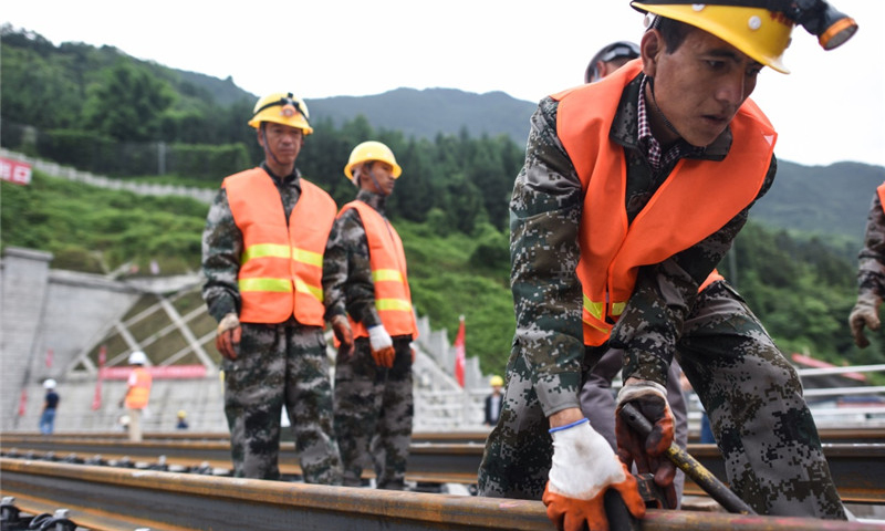 5月30日，中鐵四局的建設者在四川省宜賓市興文縣境內進行鋪軌作業。（新華社記者 薛玉斌 攝）