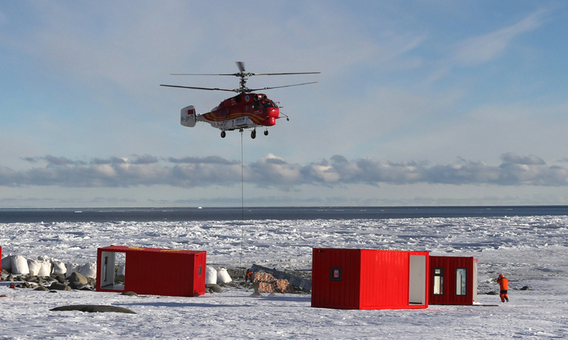 船載“雪鷹12”Ka－32直升機將物資吊運至恩克斯堡島新建站區(qū)（2017年12月9日攝）。（新華社記者 白國龍 攝）