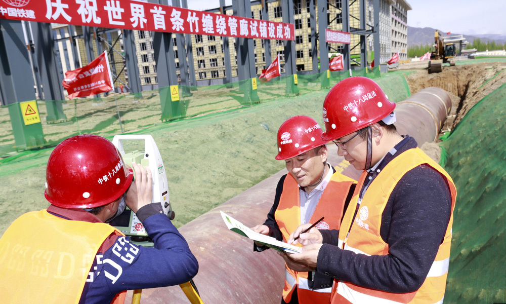 作為世界首創(chuàng)的新型城市地下管廊，竹纏繞城市綜合管廊是具有核心知識產(chǎn)權的“中國制造”產(chǎn)品，是國家《林業(yè)產(chǎn)業(yè)發(fā)展十三五規(guī)劃》的重點戰(zhàn)略林產(chǎn)項目和城市綜合管廊示范工程。圖為中國鐵建所屬中鐵十八局軌道公司項目經(jīng)理龍剛、項目書記宋鵬等在呼和浩特市元亨石墨產(chǎn)業(yè)園鋪設世界首條竹纏繞城市綜合管廊組織施工。（伍振 梁建剛 攝）