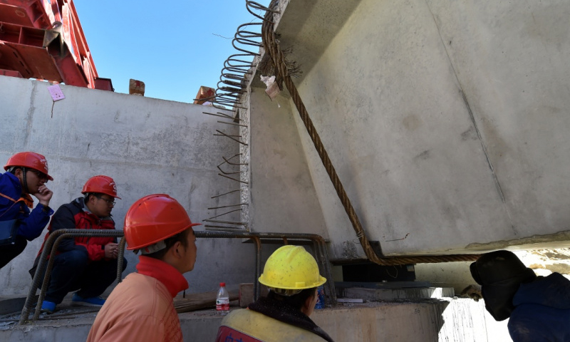 4月22日，工作人員在拉薩至那曲高等級公路昂嘎大橋施工現場檢查梁與橋墩的結合部。（新華社記者 覺果 攝）