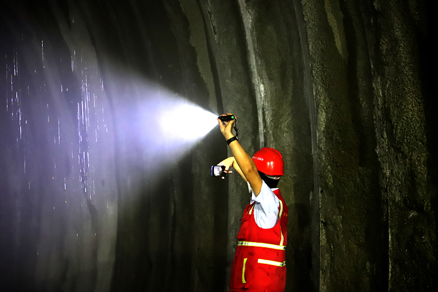 由中國鐵建所屬中鐵十八局參建的關(guān)鍵控制性工程獅子山隧洞全長29.42公里，穿越8條地質(zhì)斷裂帶，以及高烈度地震區(qū)和毒氣地段，工程面臨多項世界級技術(shù)挑戰(zhàn)。圖為技術(shù)人員查看隧道。