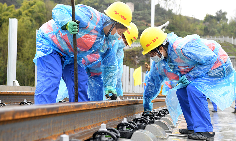 圖為3月1日，在鄭萬高鐵重慶段施工現場，施工人員進行鋪軌作業。(新華社記者 唐奕 攝)