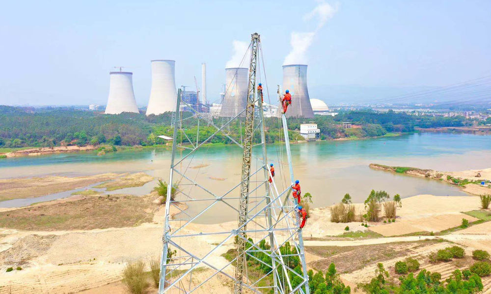 圖為4月22日10時，廣東河源，中國能建南方建投廣東火電廣東500千伏源和（河源）電廠二期接入系統工程，工作人員正在江邊組塔。（林潔明 攝）
