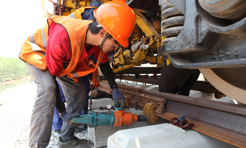 圖為4月24日，工人在景洪市大渡崗鄉大荒壩段進行鋪軌作業。新華社發（李云生 攝）
