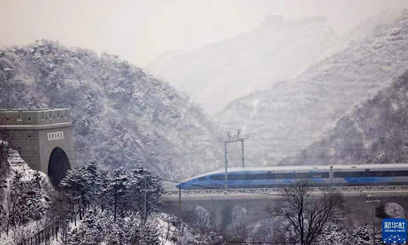 圖為1月21日，G8825次列車經(jīng)過居庸關隧道，冒雪駛向太子城。（新華社記者 邢廣利 攝）