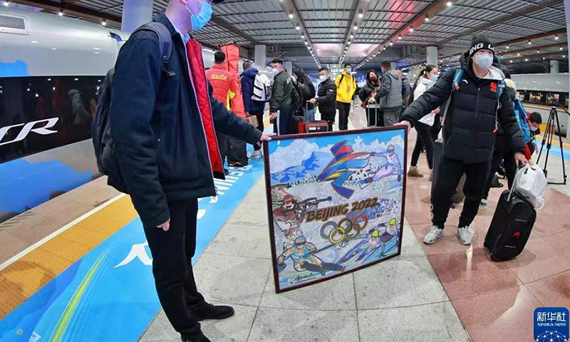 圖為1月21日，乘坐G8825次列車的乘客在展示冬奧會畫作。（新華社記者 劉續(xù) 攝）