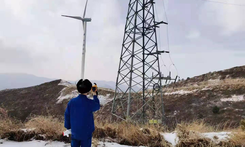 圖為華能河北清潔能源分公司涿鹿風電場檢修職工用紅外測溫儀，檢查集電線路連接處溫度是否正常，確保安全穩定運行。