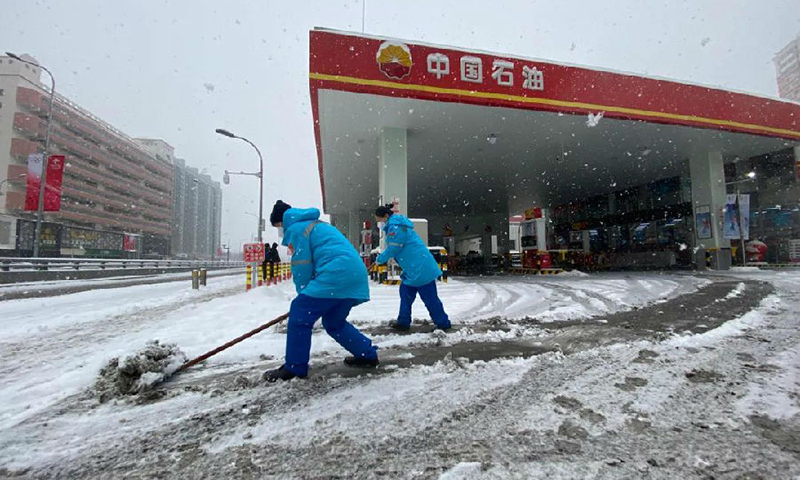  2月13日，中央氣象臺繼續發布暴雪藍色預警。大雪紛飛、氣溫驟降，讓冬季保供的步伐越發急促。不管是在保障北京冬奧的加油站，還是在全力保障眾多大中城市供氣的長慶油田，不管是在繞29道彎山路的博孜1202井邊，還是在環準噶爾盆地四千多公里油氣戰線上，中國石油員工不懼嚴寒堅守一線，用安全保供為萬戶千家送去溫暖。圖為距離鳥巢最近的石大第一加油站員工正在清雪。