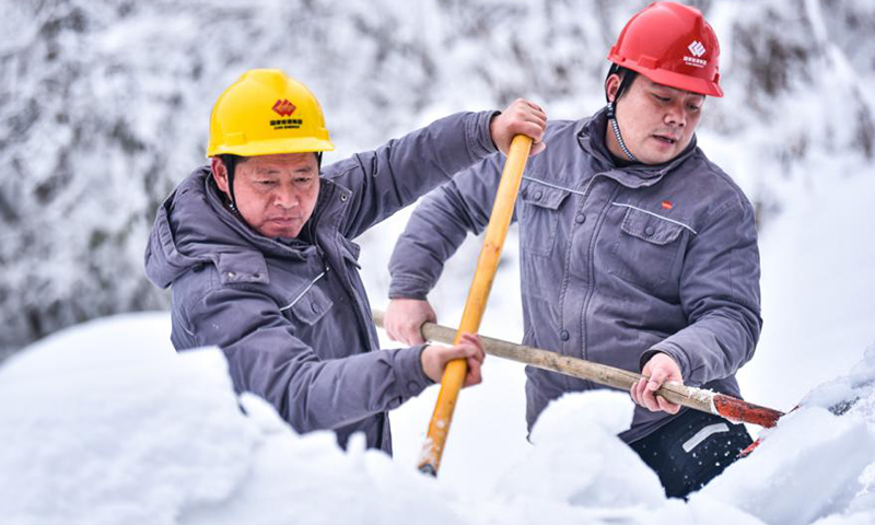 圖為42壩一級水電站兩名員工沿著引水渠道前行，不時將渠道周邊積雪推進引水渠道，為二、三、四級水電站爭取更多的水源。大雪期間，這是員工們的“必修課”。