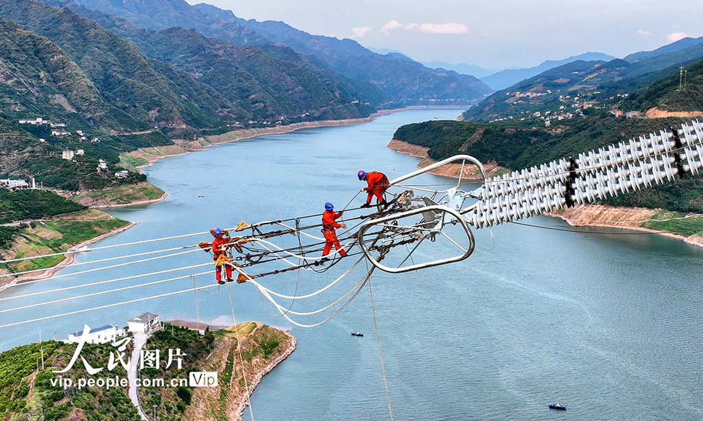 近段時間，湖北恩施地區(qū)持續(xù)高溫天氣，為保證國家重點(diǎn)工程白鶴灘——浙江±800千伏特高壓直流輸電工程施工進(jìn)度，電力工人冒著高溫酷暑，奮戰(zhàn)在施工現(xiàn)場。圖為2022年8月20日，湖北省恩施土家族苗族自治州巴東縣東瀼口鎮(zhèn)綠竹筏村，電力工人冒著40℃以上的高溫跨越長江施工作業(yè)。張遠(yuǎn)明 攝