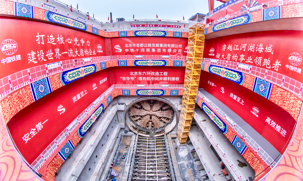 北京東六環(huán)改造工程南起京哈高速立交，北至潞苑北大街，線路全長約16公里，其中盾構(gòu)段長7.4公里，盾構(gòu)隧道直徑15.4米，最大埋深59米。首段掘進過程中，項目團隊先后攻克11項技術(shù)難題，順利穿越京哈鐵路、北京城市副中心綜合交通樞紐等30余處風險源，創(chuàng)造了單月進尺542米的掘進紀錄，申報研發(fā)工法、專利等23項，首創(chuàng)超大直徑同步雙液注漿技術(shù)填補了國內(nèi)空白，為同類型盾構(gòu)施工積累了寶貴經(jīng)驗。圖為“京華號”盾構(gòu)機到達中間風井，順利出洞。