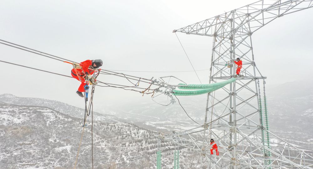 2月13日，在山西送變電公司承建的山西壽陽明泰電廠、西上莊電廠點對網(wǎng)500千伏線路工程施工現(xiàn)場，施工人員開展雪后架線作業(yè)。