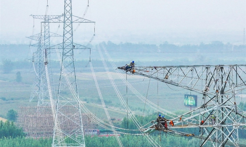 國家電網(wǎng)安徽蚌埠供電公司工作人員在500千伏濉會、禹溪線實施遷改作業(yè)。