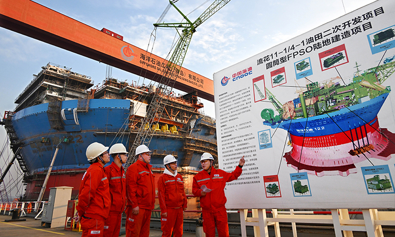 12月4日，工程技術人員在建造中的“海洋石油122”旁交流。新華社記者 李紫恒 攝