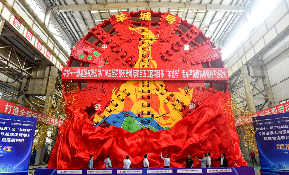 近日，由中鐵十一局和鐵建重工共同研制的廣州東至花都天貴城際全線最大直徑盾構機“羊城號”在湖南長沙成功下線，即將開始隧道掘進工作。廣州東至花都天貴城際鐵路項目是推動粵港澳大灣區高質量構建“一張網、一張票、一串城”廣州都市圈城際網絡的骨干線路，建成通車后，將與廣州地鐵十八號線、南珠（中）城際鐵路貫通運營，串聯起廣州、珠海、中山三市，拉近廣州南沙、番禺、白云、花都等城區時空距離。圖為下線現場。