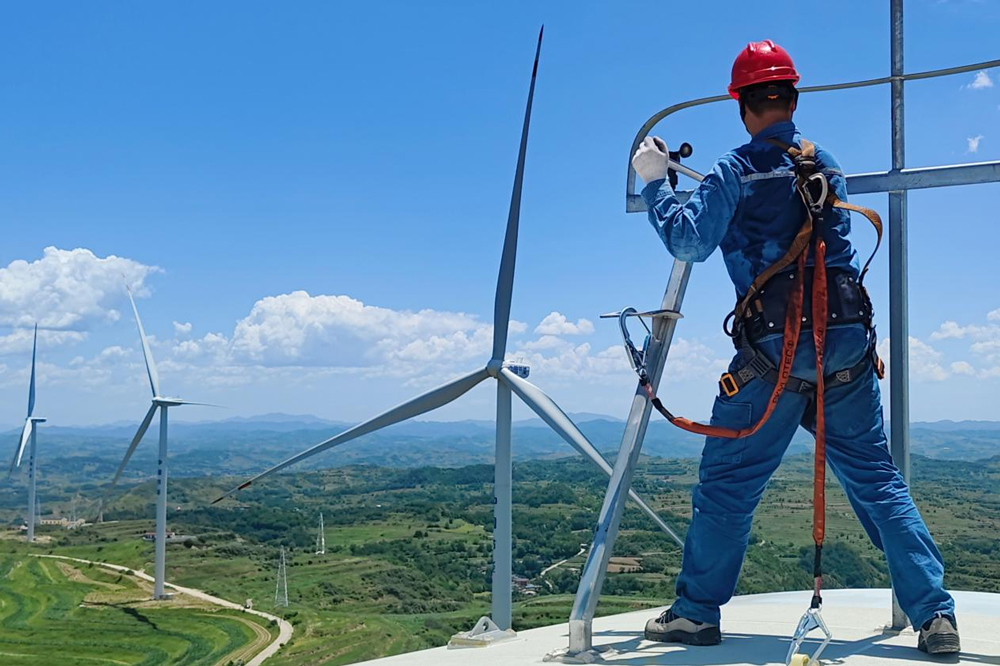 針對夏季高溫環境下風機的特定問題，中國節能各風電場對風機主齒箱散熱系統等易高溫部位進行專項清理維護并及時采取降溫措施。圖為中國節能所屬風電甘肅區域公司天水風場檢修員更換風機上的風速風向儀。