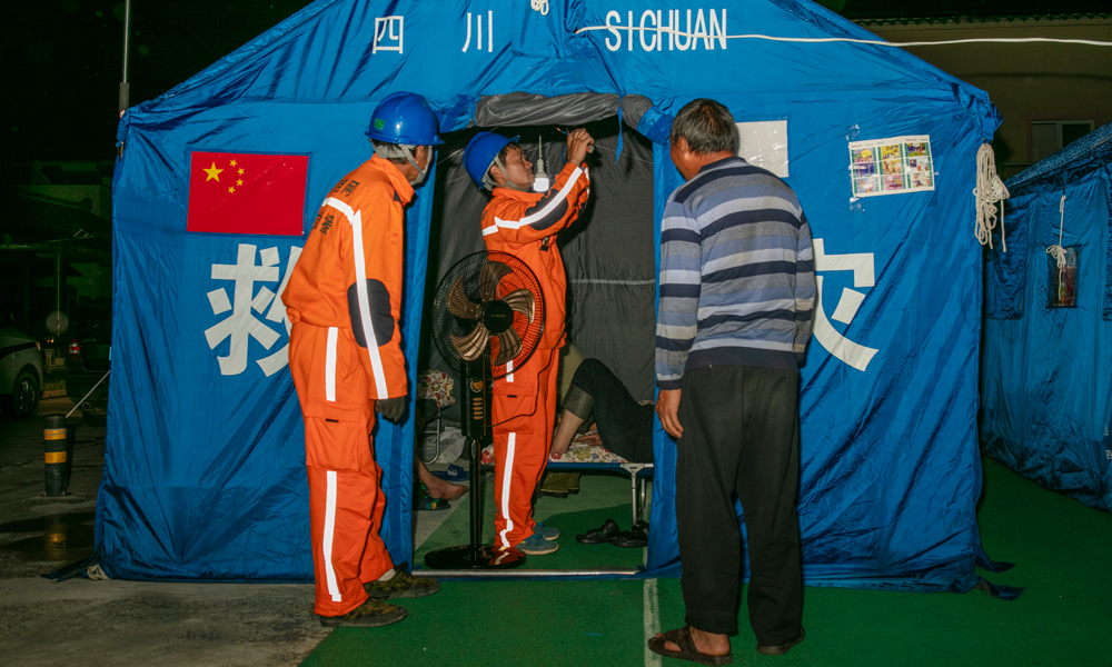 國家電網四川甘孜供電公司工作人員在康定市姑咱鎮郎鼓村安置點為受災群眾送來風扇。