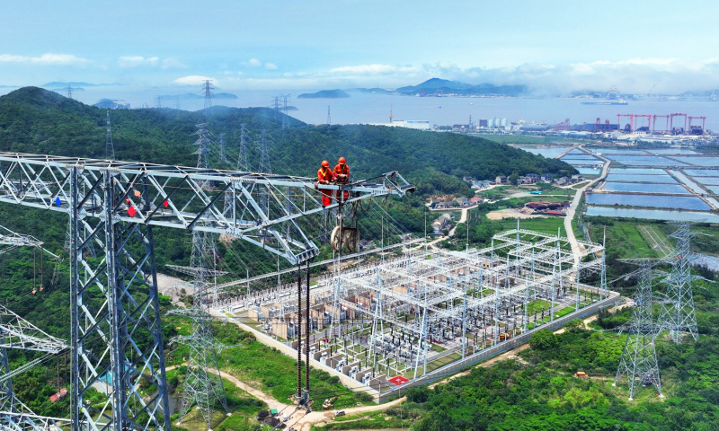 近日，浙江舟山500千伏聯網輸變電工程迎來首次雙線（洛春5495線、洛曉5496線）檢修。自2019年投運以來，該工程已累計輸電超330億千瓦時。國網浙江省電力有限公司安排6名檢修人員以雙線同步走線方式開展檢修作業，為浙東電網迎峰度夏奠定堅實基礎。圖為檢修人員對鐵塔構件進行檢查。