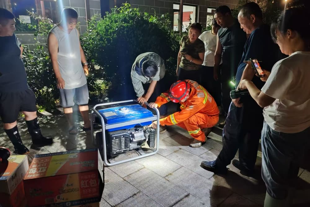 7月27日22時，國網北京電力綜合應急救援隊隊員付佳文為密云河北村村委會送去兩臺發電機作為應急電源，并為村民講解使用方法。