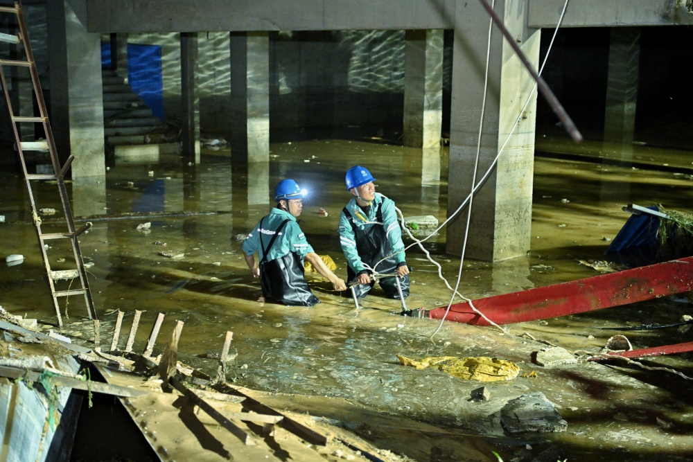 7月26日，國網河北衡水供電公司支援隊員在保定阜平縣假日蘭庭小區抽排地下配電室附近積水。