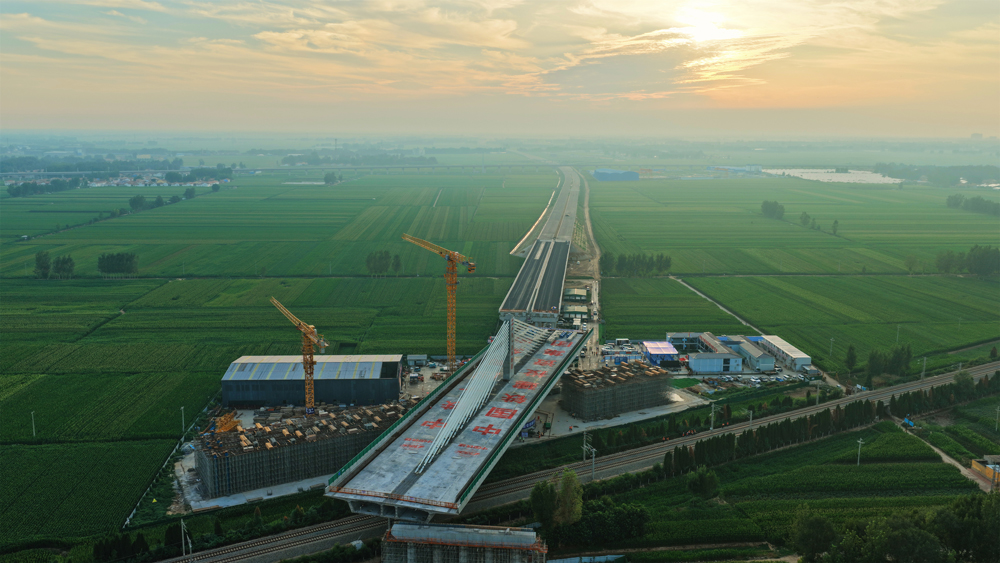 這座轉(zhuǎn)體橋主跨100米、邊跨70米，重量達(dá)23500噸，歷時(shí)40分鐘逆時(shí)針旋轉(zhuǎn)后精準(zhǔn)就位，創(chuàng)下山東省首個(gè)跨鐵路不對稱矮塔斜拉轉(zhuǎn)體橋紀(jì)錄，為項(xiàng)目2025年年底建成通車奠定了堅(jiān)實(shí)基礎(chǔ)。圖為大橋轉(zhuǎn)體過程中。 