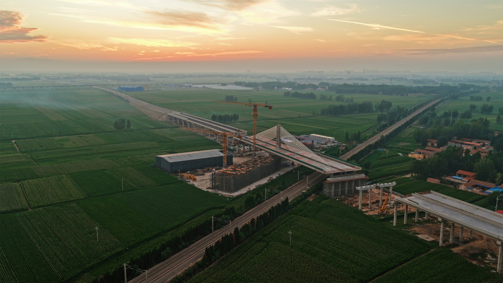 項(xiàng)目團(tuán)隊(duì)首創(chuàng)應(yīng)用“球鉸支座+智能牽引”系統(tǒng)，以兩臺(tái)連續(xù)千斤頂同步發(fā)力，精準(zhǔn)驅(qū)動(dòng)重量相當(dāng)于1.5萬輛小汽車的橋體平穩(wěn)轉(zhuǎn)動(dòng)。同時(shí)運(yùn)用BIM技術(shù)構(gòu)建三維模型，并依托北斗實(shí)時(shí)監(jiān)控系統(tǒng)，對橋梁轉(zhuǎn)角等關(guān)鍵參數(shù)實(shí)施毫秒級捕捉與動(dòng)態(tài)調(diào)整。圖為大橋完成轉(zhuǎn)體施工。