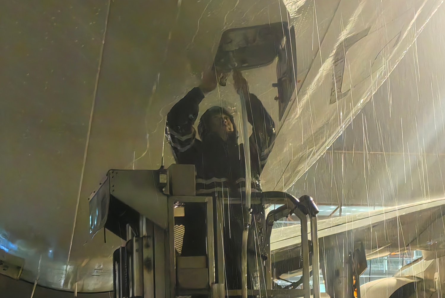 暴雨如注，中航集團(tuán)水車保障輔助操作員進(jìn)行加清作業(yè)。