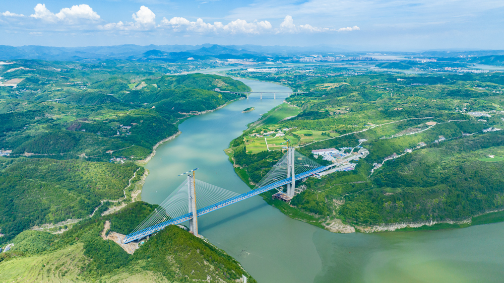 近日，湖北十堰，西十高鐵漢江特大橋建設現場一片繁忙景象，中鐵十一局建設者正加緊進行鋼桁梁焊接，沖刺鋼桁梁合龍。圖為漢江特大橋航拍。