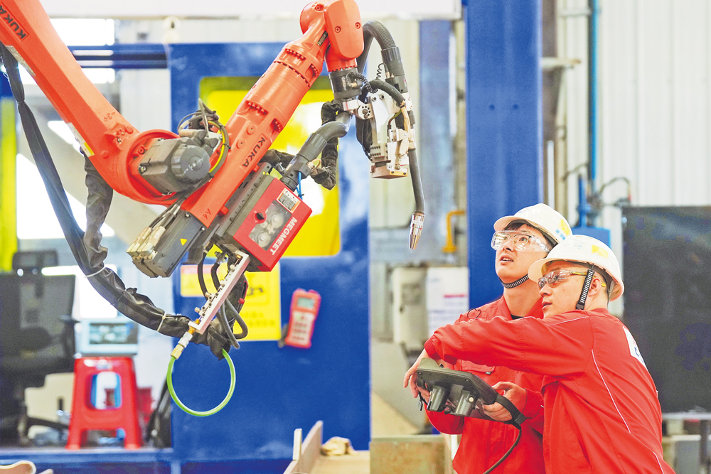 柔性制造智能焊接機(jī)器人的研發(fā)涉及機(jī)械工程、人工智能、傳感等多學(xué)科交叉技術(shù)，對(duì)智能決策、環(huán)境感知和控制系統(tǒng)等要求都非常高，目前國(guó)際上僅有少數(shù)國(guó)家掌握該項(xiàng)關(guān)鍵技術(shù)。圖為海油工程“智能焊接突擊隊(duì)”技術(shù)人員調(diào)試焊接機(jī)器人。