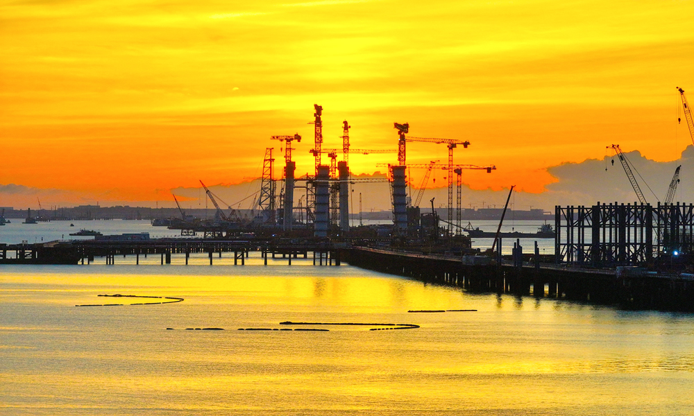 初秋晨曦，橙紫交融。中交二航局參建的廈金大橋（廈門段）項目施工現(xiàn)場披上一身霞光，在云浪翻涌間盡顯鋼鐵長虹磅礴氣勢。當(dāng)前，項目取得重要進展，控制性工程劉五店航道橋是福建省首座離岸式海中懸索橋，其西主塔已完成9個節(jié)段吊裝，西錨碇正穩(wěn)步推進錨體支架搭設(shè)。 