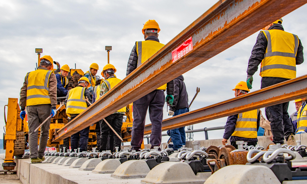 杭臺高鐵溫玉段是一條集路網、城際、旅游及經濟開發功能于一體的客運專線，主要承擔城際客流。項目建成運營后將填補玉環市鐵路空白，形成臺州“縣縣通鐵路、鐵路網全覆蓋”的交通新格局，對于加快打造浙江省1小時高鐵交通圈、完善區域路網結構布局、促進沿線文旅產業融合發展等具有重要意義。圖為施工人員在鋪設長軌。