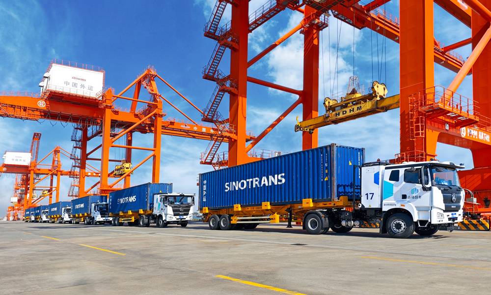 “十四五”時期，招商局集團(tuán)旗下中國外運(yùn)持續(xù)提升產(chǎn)業(yè)鏈供應(yīng)鏈韌性與安全水平，自有海外服務(wù)網(wǎng)絡(luò)覆蓋全球45個國家和地區(qū)；穩(wěn)定運(yùn)營全貨機(jī)定期國際航線，年度固定運(yùn)力約26萬噸；國際班列運(yùn)量累計突破200萬標(biāo)箱，汽運(yùn)網(wǎng)絡(luò)覆蓋全國各省份超300個城市，自動駕駛高速干線商業(yè)運(yùn)營里程超300萬公里。圖為自動駕駛電動集卡車隊行駛在中國外運(yùn)江門高新港。