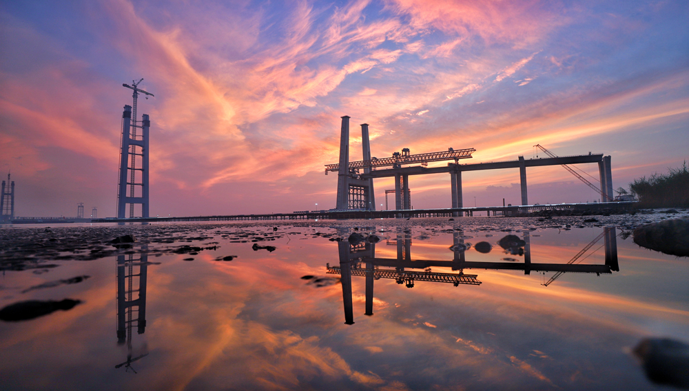 落日熔金映江天，霞光萬道染塔尖。目前，中國交建旗下中交二航局承建的張靖皋長江大橋南主塔建設高度已超300米，預計2025年底可實現封頂，屆時高度將達350米，為世界最高懸索橋索塔。