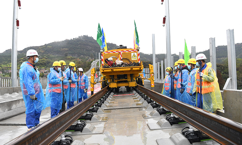 鄭萬高鐵是我國“八縱八橫”高速鐵路網中沿江通道和呼南通道的重要組成部分。線路起于河南省鄭州市，止于重慶市萬州區，新建線路全長約818公里，設計時速350公里。圖為3月1日，在鄭萬高鐵重慶段施工現場，施工人員進行鋪軌前的準備工作。(新華社記者 唐奕 攝)