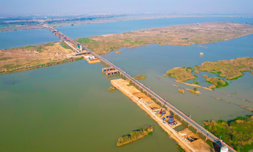 圖為中鐵十六局承建的寧淮城際鐵路項(xiàng)目洪澤至金湖雙線特大橋，全長(zhǎng)約2400米，跨越Ⅲ級(jí)航道，為全線重難點(diǎn)控制性工程。目前，大橋樁基、承臺(tái)、墩身施工正在同步推進(jìn)中，預(yù)計(jì)8月份可完成全部墩身施工任務(wù)。項(xiàng)目建成后，將進(jìn)一步完善江蘇省內(nèi)城際軌道交通網(wǎng)布局，對(duì)促進(jìn)南京都市圈和沿線地區(qū)經(jīng)濟(jì)社會(huì)發(fā)展、助力長(zhǎng)三角高質(zhì)量一體化發(fā)展等具有重要意義。
