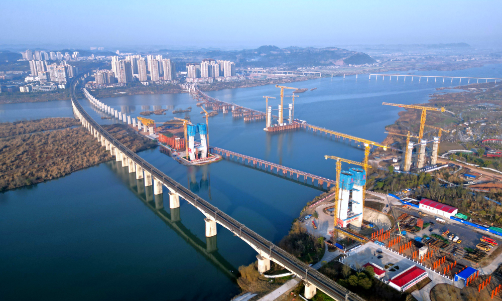 圖為中鐵十七局參與建設(shè)的“西南第一橋”——成達(dá)萬(wàn)高速鐵路涪江特大橋。目前，主橋中塔柱施工和主橋邊跨現(xiàn)澆支架搭設(shè)正在全面推進(jìn)，建設(shè)團(tuán)隊(duì)對(duì)主塔高空作業(yè)安全設(shè)備進(jìn)行專項(xiàng)檢查，同時(shí)創(chuàng)新應(yīng)用工藝工法，搭建智慧工地平臺(tái)，高質(zhì)量、高效率加快進(jìn)度，全力打造精品工程和綠色工程。項(xiàng)目建成后將實(shí)現(xiàn)350萬(wàn)遂寧人民進(jìn)入“高鐵時(shí)代”的愿望，助力成渝地區(qū)雙城經(jīng)濟(jì)圈建設(shè)。