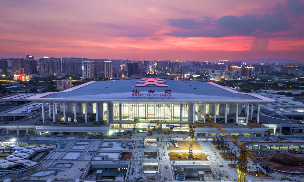 由中鐵建設承建的新建汕頭站是國家“八縱八橫”沿海高鐵的重要節點。工程共分兩期，一期新建東站房，二期改擴建既有西站房，建筑規模10萬平方米。建成后汕頭站將成為集高鐵、普鐵、城際、地鐵為一體的綜合樞紐。當前，一期站房工程已進入靜態驗收階段，1200余名建設者戰高溫保進度，各項施工作業正全力沖刺收尾。圖為正在施工中的汕頭站夜景。